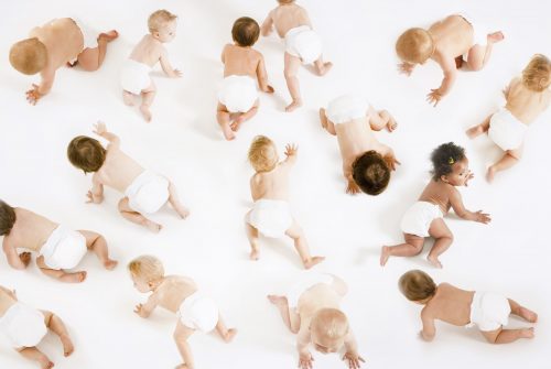 Group of multiethnic babies crawling isolated on white background