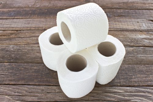 Toilet paper rolls on wooden background